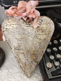 an old typewriter with a heart shaped paper on it and a pink flower sitting next to it