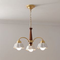 a chandelier with three lights hanging from it's sides in a room