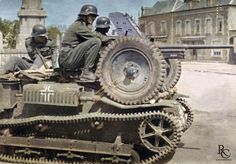 two men sitting on top of an old tank