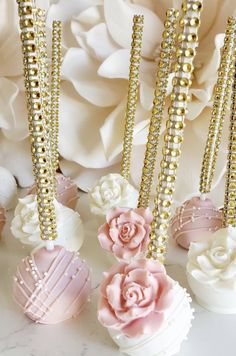 some pink and white cupcakes are on a table with flowers in the background