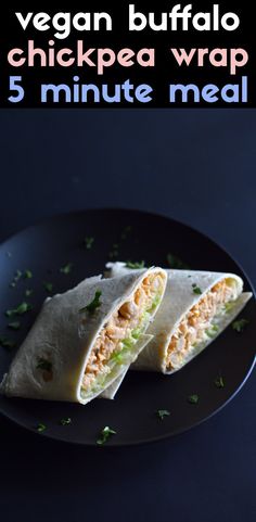 a black plate topped with two burritos cut in half