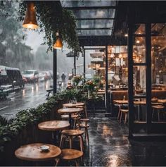 an outdoor restaurant with tables and umbrellas on a rainy day