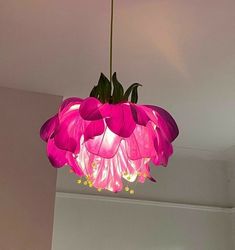 a pink flower hanging from a ceiling light in a room with white walls and flooring