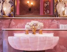 a bathroom with pink walls and gold fixtures