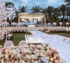 an outdoor wedding setup with flowers and chandeliers