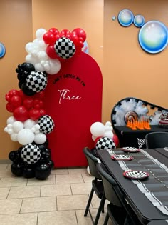 a table set up with black and white balloons