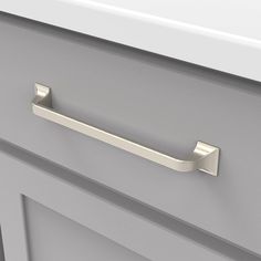 a close up of a drawer handle on a cabinet with drawers in grey and white