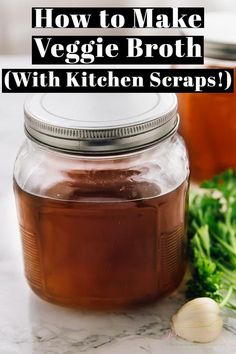 a jar filled with brown liquid sitting on top of a counter next to garlic and broccoli