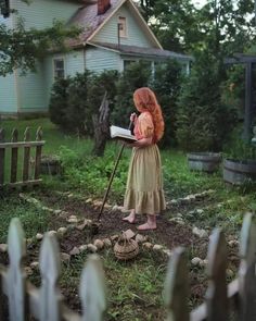 a woman is standing in the yard looking at something