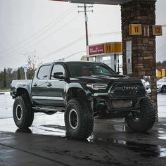 a black truck parked in front of a gas station