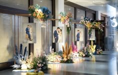 an artistic display with flowers and pictures on the wall in front of them is shown