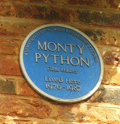 a blue plaque on the side of a brick building that says montty python