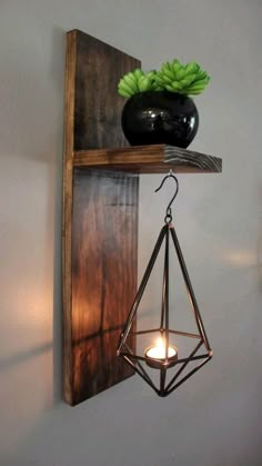 a wooden shelf with a candle holder on it and a black vase in the corner