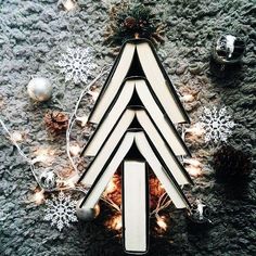 a christmas tree made out of books on top of a carpet with lights and ornaments around it