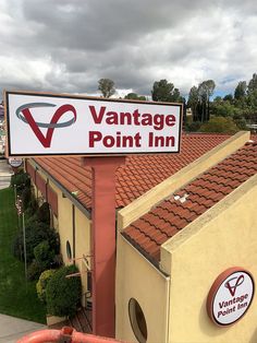 a sign for vantage point inn in front of a building with red tile roofing