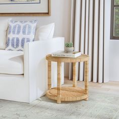 a living room with a white couch and coffee table in front of a painting on the wall