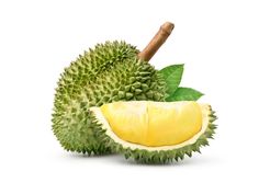 a durian fruit cut in half and sitting on the ground with leaves around it