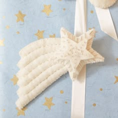 a blue wrapping paper with gold stars and a white angel ornament on it