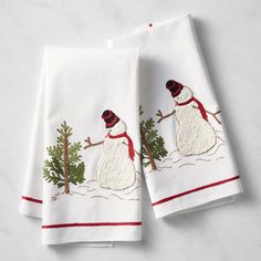 two white towels with embroidered snowmen on them