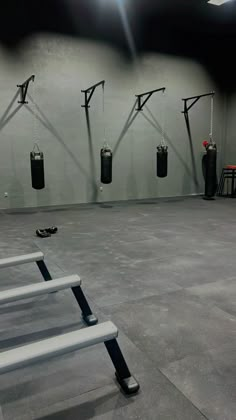 an empty gym with boxing gloves hanging from the ceiling