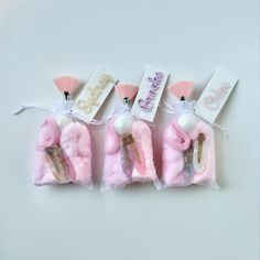 three small pink items with tags attached to them