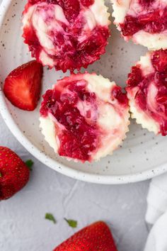 strawberry cupcakes with white frosting and fresh strawberries on the side for garnish