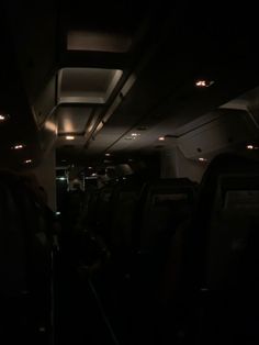 the interior of an airplane at night with its lights on and no people in it