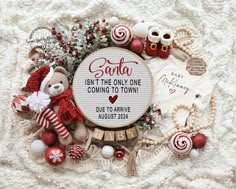 a baby announcement surrounded by christmas ornaments and other holiday items on a white blanket with the words santa isn't the only one coming to town