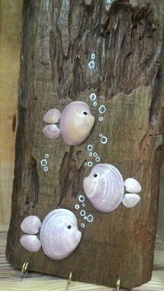 three white fish on a tree trunk with bubbles in the water and some gold hooks