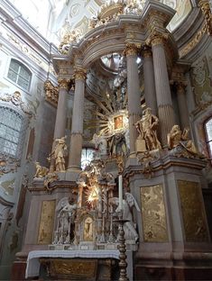 the interior of a church with gold and white decorations on the walls, pillars and ceiling