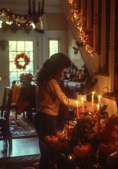 a woman standing in front of a table filled with candles