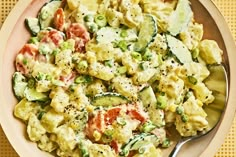 a bowl filled with macaroni salad on top of a table next to a fork