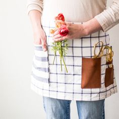 a woman is holding flowers in her pocket