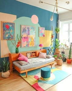 a living room filled with lots of furniture and colorful paintings on the wall above it