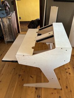 a dog is standing next to a table made out of plywood