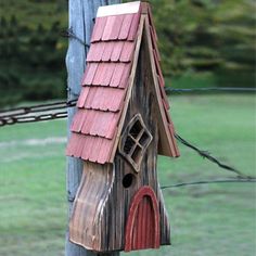 a wooden birdhouse hanging from a telephone pole