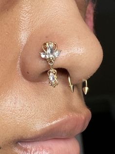 a woman's nose with two piercings attached to the side of her nose