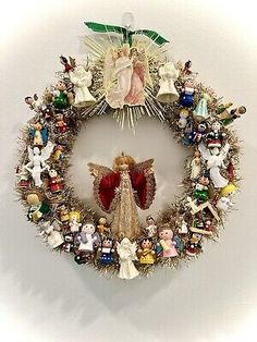 a christmas wreath with an angel surrounded by figurines