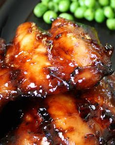 chicken wings with sauce and green peas on the side