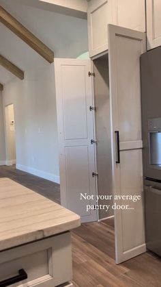 an empty kitchen with stainless steel appliances and wood flooring is seen in this image