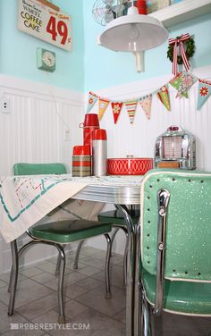 a kitchen table and chairs in front of a wall with bunting flags on it