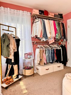 an organized closet with clothes and shoes on shelves next to a bed in front of a window