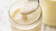 a spoon in a jar filled with cream