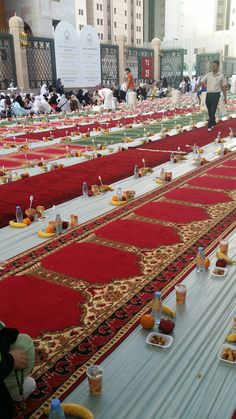 rows of tables covered in red and gold cloths with plates of food on them