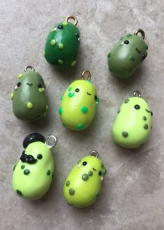 six green and yellow cactus charms sitting on top of a table