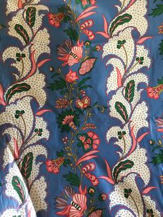 the fabric is blue with pink flowers and green leaves