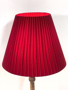 a red lampshade sitting on top of a wooden table