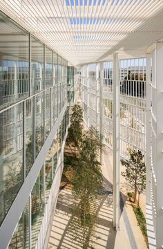 the inside of a large building with white walls and glass windows on both sides,