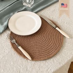 a place mat with silverware on it next to an empty plate and glass vase