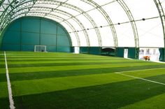 an indoor soccer field with green grass